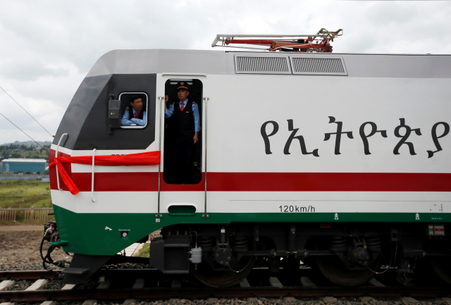 Chinese train masters look out from a train as they wait for passengers during the inauguration of the new train line linking Addis Ababa to the Red Sea state of Djibouti, in Addis Ababa, Ethiopia, October 5, 2016. REUTERS/Tiksa Negeri