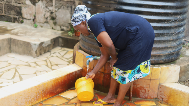 A Baruwa resident fetches water from a home in the area in Lagos, Nigeria on October, 10, 2021. Bukola Adebayo/Thomson Reuters Foundation.