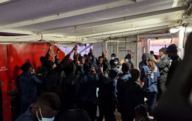 Survivors celebrate on the desk of the Ocean Viking after being told they are scheduled to disembark in Italy, December 27, 2022. Thomson Reuters Foundation/Frey Lindsay