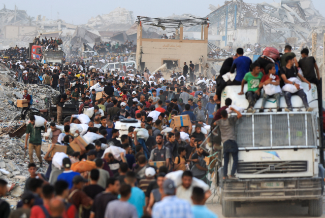 Palestinians carry aid supplies, that entered Gaza on trucks through Israel, in Beit Lahia, in the northern Gaza Strip July 29, 2025. REUTERS/Dawoud Abu Alkas