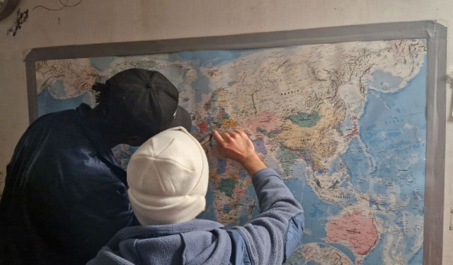 Unaccompanied minor “Emmanuel” from Cameroon and rescue worker Hector pointing out Ravenna in Northern Italy, where Emmanuel will soon disembark, on board the Ocean Viking, December 19, 2022. Thomson Reuters Foundation/Frey Lindsay