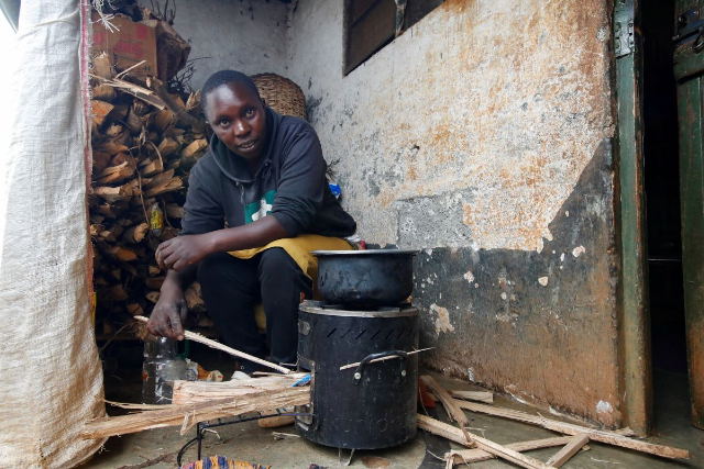 A woman cooks using a clean-stove inside her house at Kachoroba village of Kiambu county Kenya, August 16, 2023. REUTERS/Monicah Mwangi