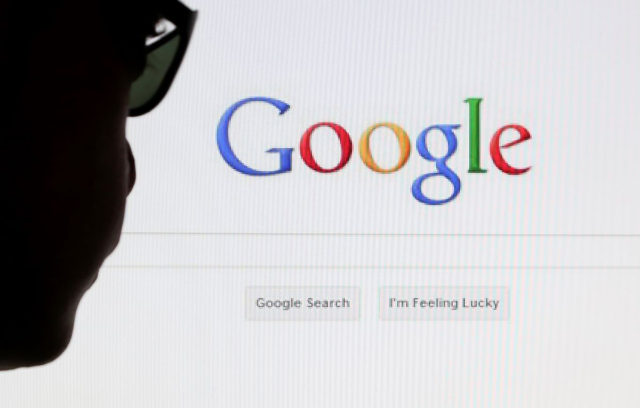 A computer user poses in front of a Google search page in this photo illustration taken in Brussels May 30, 2014