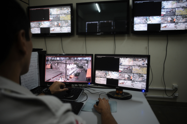 A police officer watches live security cameras aimed at different points of the city in Salvador, Bahia State, Brazil, March 28, 2013. REUTERS/Lunae Parracho