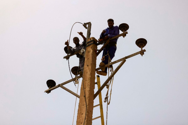 Electricity workers rehabilitate the power lines at the central market during clashes between the paramilitary Rapid Support Forces and the army in Khartoum North, Sudan April 27, 2023