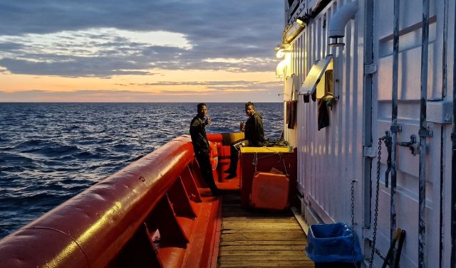The rescue crew of the Ocean Viking approach a boat in distress, carrying 113 people, on the border of the Maltese and Libyan search and rescue zones. The group had been at sea for more than 24 hours after setting off from near Zuwara in Libya, December 27, 2022. Thomson Reuters Foundation/Frey Lindsay