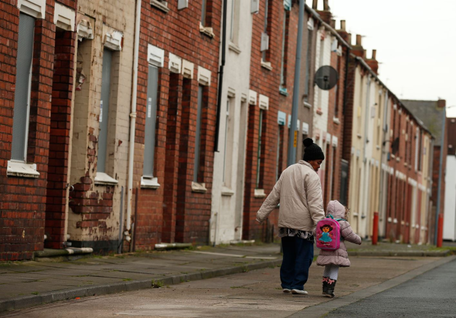 A woman and child walk along a terraced street in the Gresham area of Middlesbrough, northern Britain, January 20, 2016. Asylum seekers in the northern English town of Middlesbrough are suffering abuse because they have been housed in properties that almost all have red front doors, making them easy targets for racists. REUTERS/Phil Noble