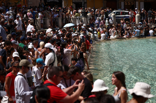 Crowds of tourists visit the Trevi Fountain in Rome, Italy, August 8, 2024. REUTERS/Guglielmo Mangiapane