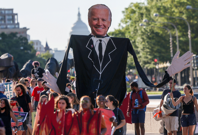 Environmental activists march towards the White House to demand U.S. President Joe Biden stop fossil fuel projects and put climate justice at the heart of his infrastructure plans, in Washington, U.S., June 30, 2021. REUTERS/Evelyn Hockstein