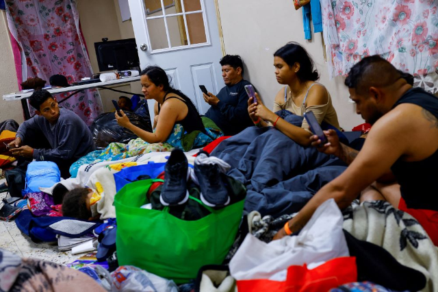 Migrants, mostly from Venezuela seeking asylum in the U.S., use their phones to access the U.S. Customs and Border Protection CBP ONE application, in a shelter near the border between Mexico and the United States, in Ciudad Juarez, Mexico February 24, 2023