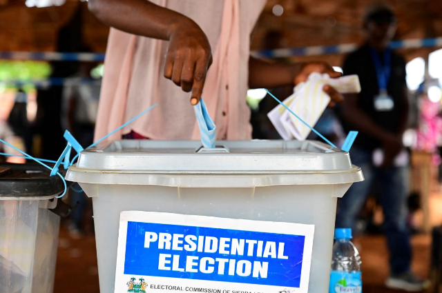 A voter casts her ballot for the national election at a polling station in Freetown, Sierra Leone, June 24, 2023