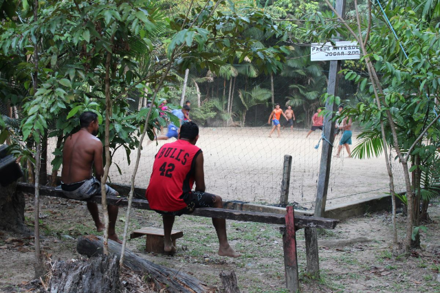 Young men watch boys play soccer in the Amazon ‘agro-extractivist’ settlement project (PAE) Nossa Senhora de Nazaré, in the in the Caripetuba Island, one of the potentially affected by a port project from American grain trader Cargill, in Abaetetuba, Brazil, August 10, 2023.THOMSON REUTERS FOUNDATION/André Cabette Fábio