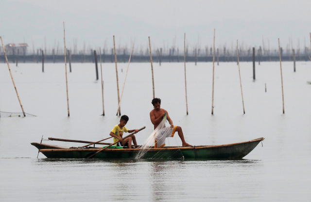 Fishermen recover nets at their fishpens in Laguna de Bay, in Muntinlupa, Metro Manila, in Philippines, September 14, 2018. REUTERS/Erik De Castro