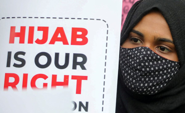 A Muslim student holds a placard during a protest by Muslim Students Federation (MSF) against the recent hijab ban in few of Karnataka’s colleges, in New Delhi, India, February 8, 2022. REUTERS/Anushree Fadnavis