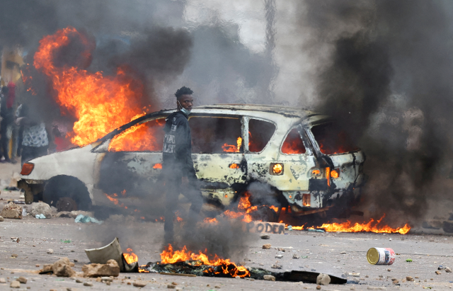 A protester looks on near a burning barricade during a "national shutdown" against the election outcome, in Maputo, Mozambique, November 7, 2024. REUTERS/Siphiwe Sibeko