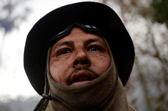 A volunteer firefighter member rests while working to extinguish a fire rising in the Pantanal, in Corumba, Mato Grosso do Sul state, Brazil, June 14, 2024. REUTERS/Ueslei Marcelino