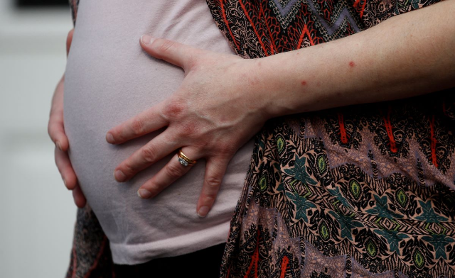 A woman who is 8 months pregnant poses for a photograph outside her home, Manchester, Britain April 9, 2020. REUTERS/Phil Noble