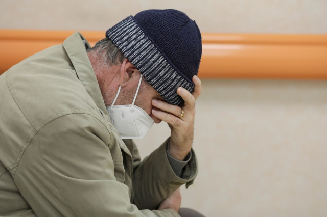 A coronavirus disease (COVID-19) patient wearing a PPE mask sits in the emergency unit hallway of the National Institute for Infectious Diseases "Matei Bals" in Bucharest, Romania, October 11, 2021. Inquam Photos/Octav Ganea via REUTERS