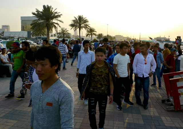 Migrant workers walk on the corniche in Doha, Qatar April 14, 2017