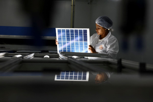 A woman looks at a solar panel, at a factory called Ener-G-Africa, where high-quality solar panels made by an all-women team are produced, in Cape Town, South Africa, February 9, 2023