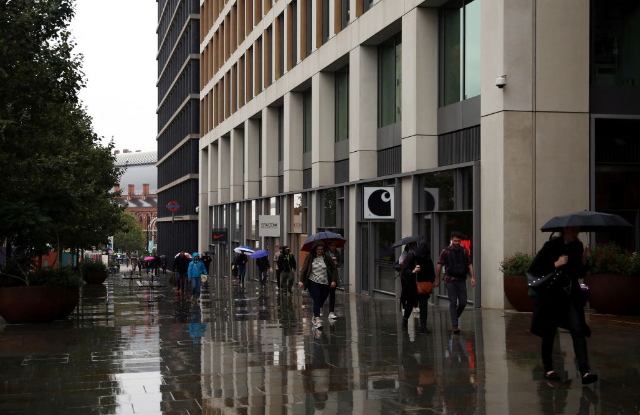 People walk beneath a surveillance camera in the Kings Cross area in London, Britain, August 14, 2019